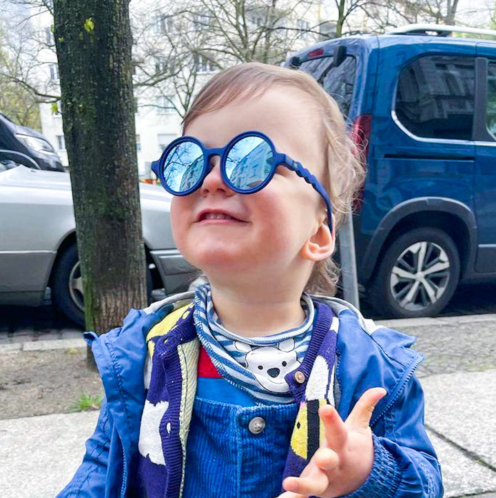 Baby boy wearing round blue polarised sunglasses for baby and kids. Designed in Australia.